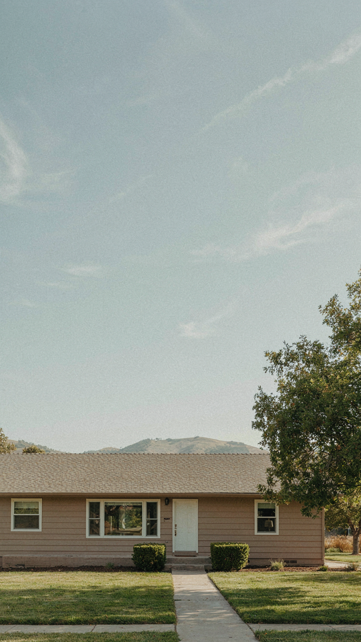 A long ranch house exterior in warm taupe highlights its horizontal lines.