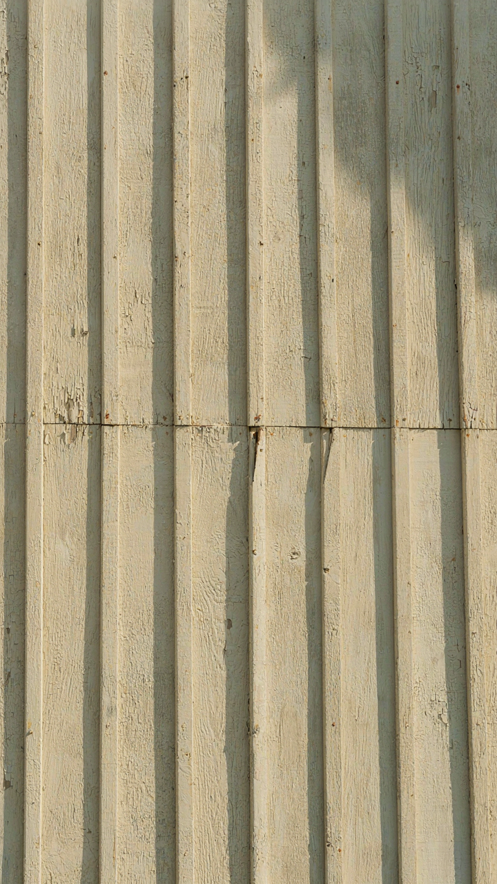 A close-up of naturally aging board and batten siding on a barn style home.