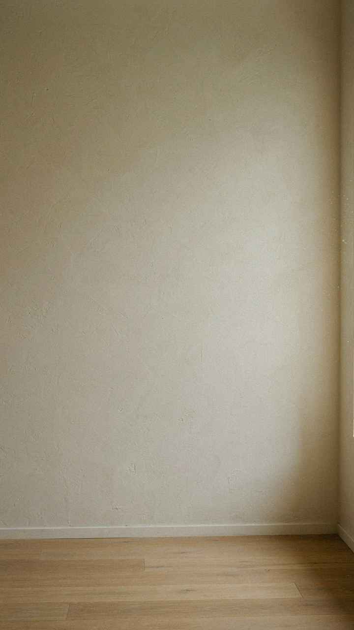 A cream colored wall glows warmly in morning sunlight.