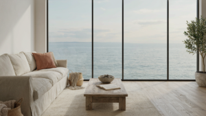 A bright coastal living room with neutral colors and a view of the ocean.