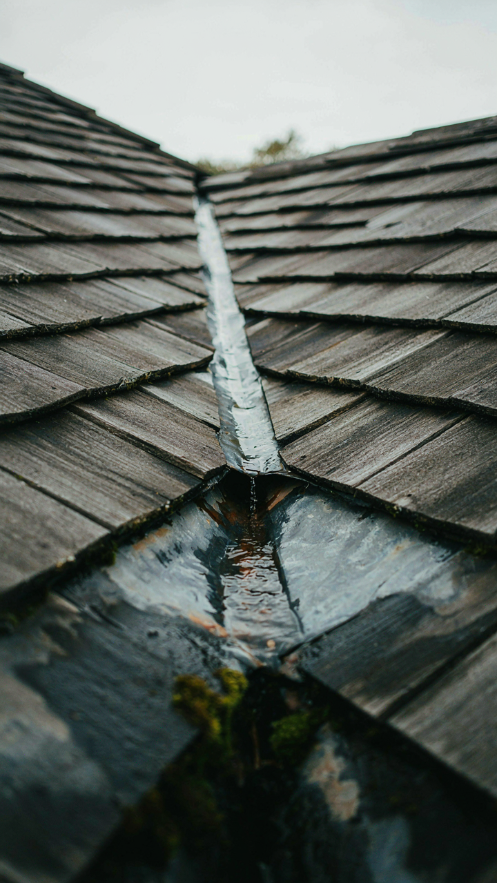 Close-up of a damaged roof valley where a dormer meets the main roof.