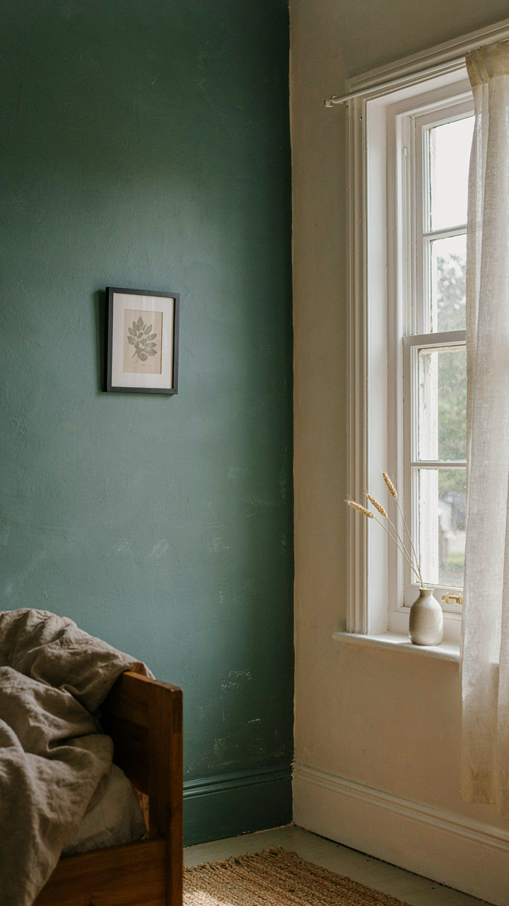 A small farmhouse bedroom with one deep sage accent wall.