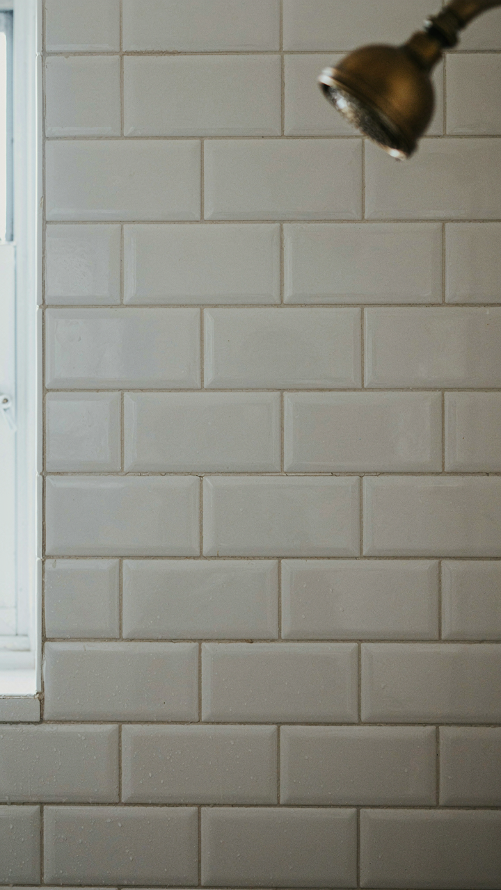 Close-up of durable subway tiles in a shower with slightly darkened grout lines.