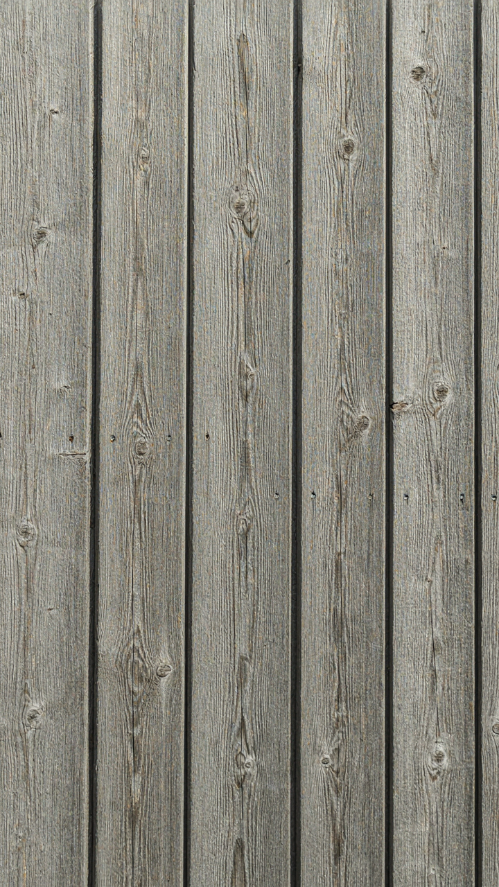 Untreated spruce siding on a Scandinavian cabin with oxidized silver-gray fibers.