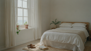 A tranquil coastal farmhouse bedroom with a wooden bed, white linens, and soft natural light.