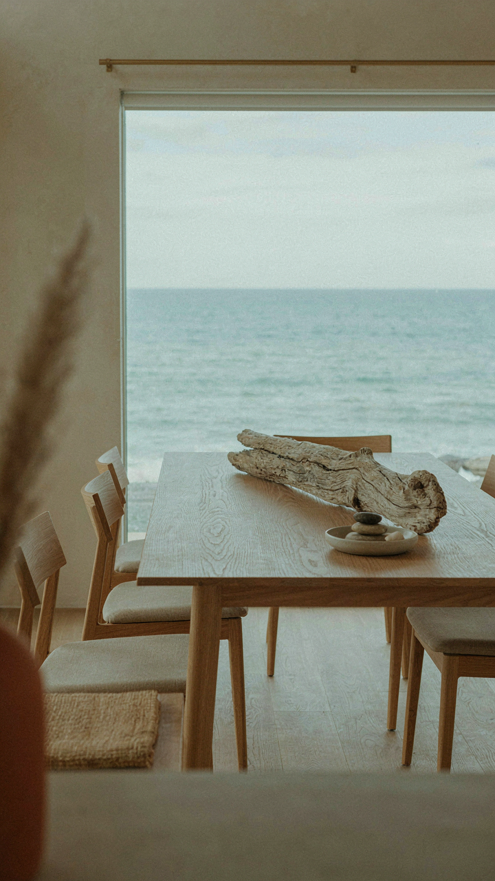 A wooden dining table with a single piece of weathered driftwood.