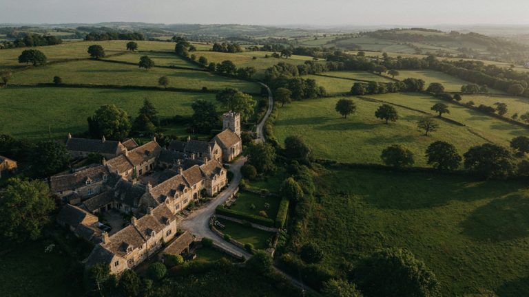 Aerial view of a picturesque Cotswold village with honey stone cottages.