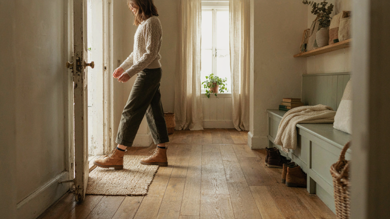 A person walks through a perfectly organized cottage mudroom, leaving clutter behind.