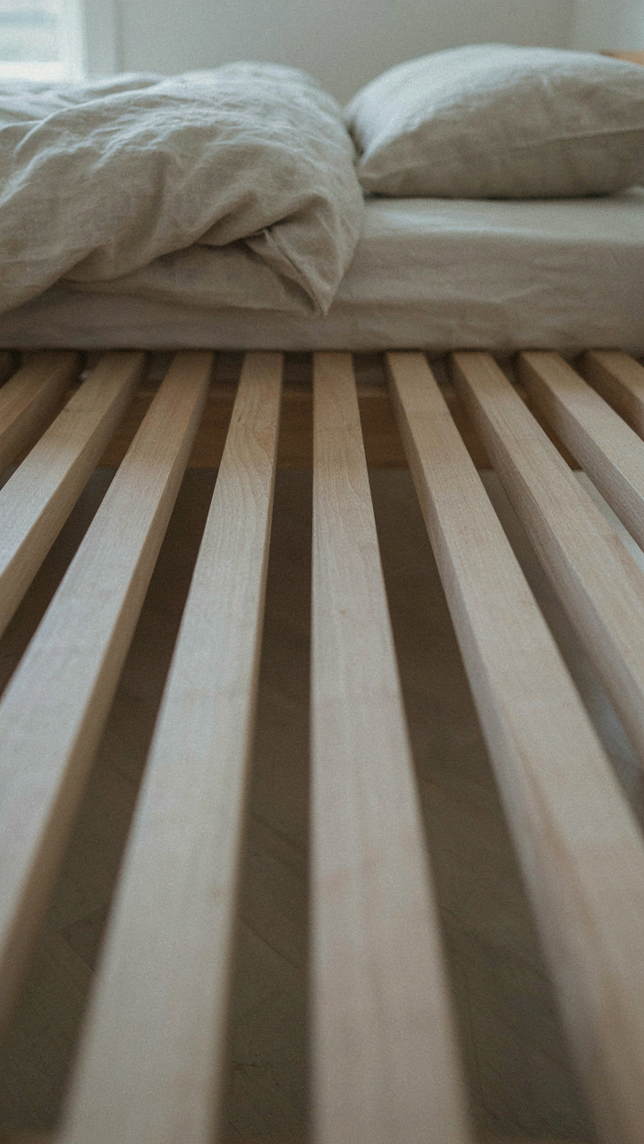 A close-up shows the strong, evenly spaced slats of a wooden bed frame.