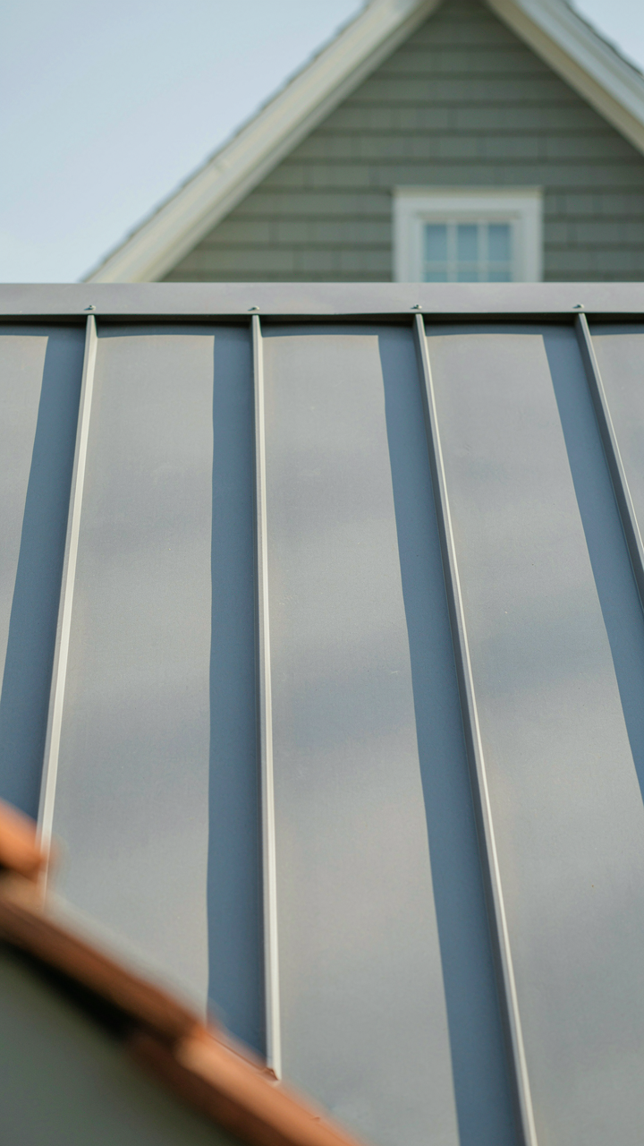 A close-up of a light-colored standing seam metal cottage roof panel.