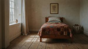 A warm country bedroom with a patterned quilt on a bed and a rustic wooden nightstand.