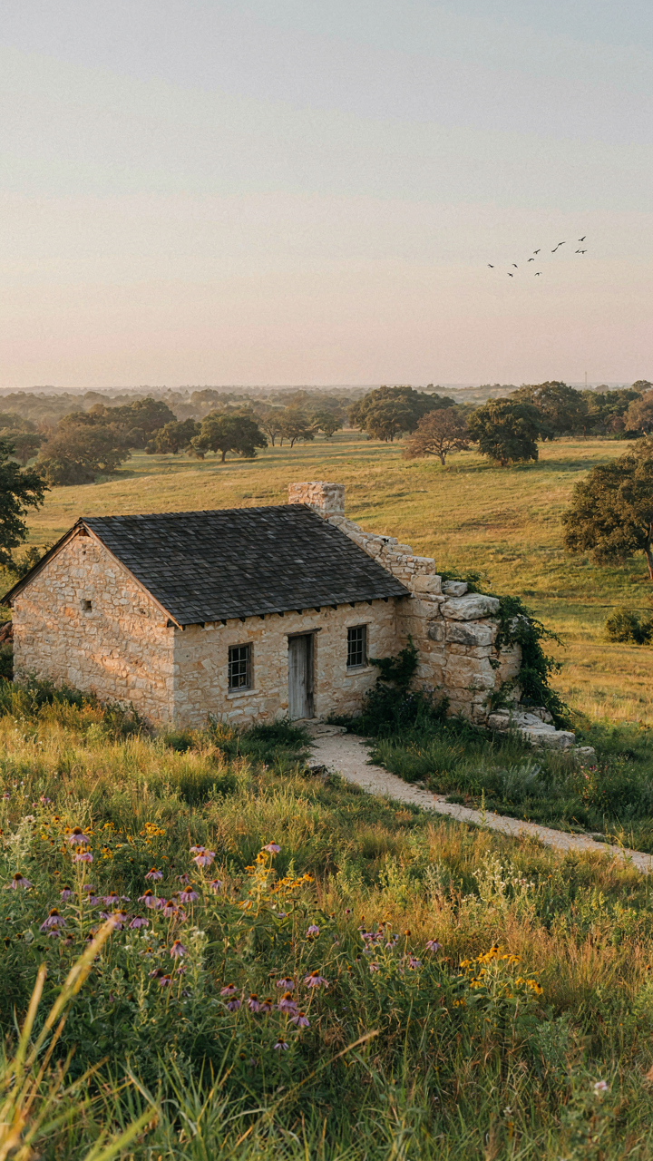 A hill country farmhouse blending into the natural landscape.