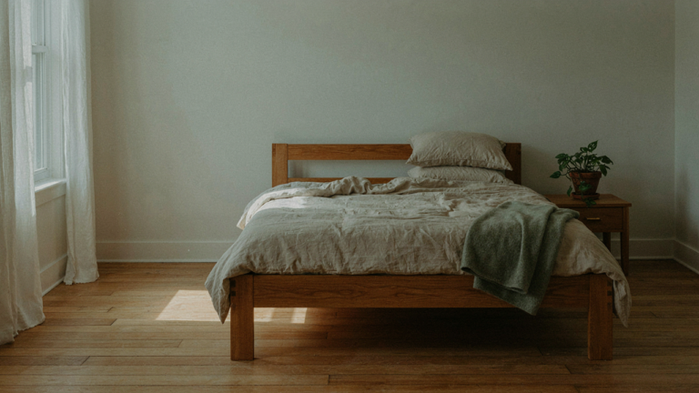 A serene craftsman bedroom with a solid wood bed and soft natural light.
