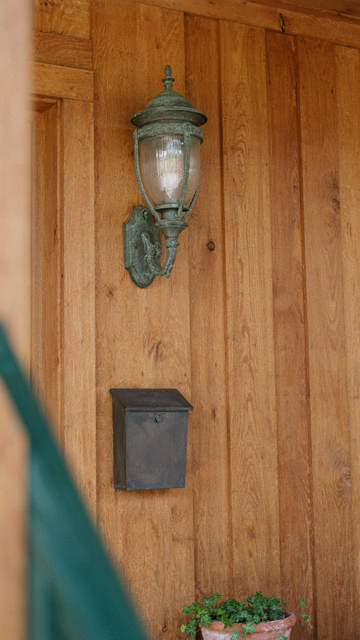 A close-up of a craftsman bungalow's bronze porch light and simple mailbox.