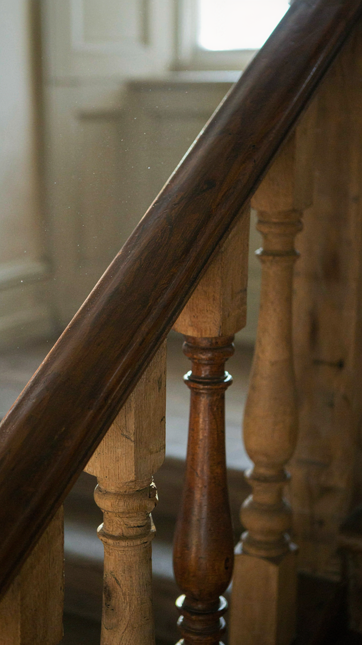 A smooth, worn wooden bannister in a historic country house.