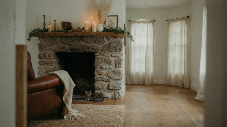 A farmhouse living room with a stone fireplace and a mantelpiece decorated with vintage items.
