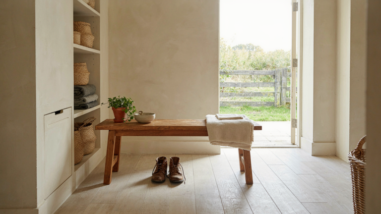A neat farmhouse mudroom with built-in storage, a bench, and tile flooring.