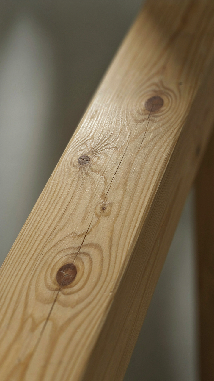 A close up shows the flat, printed grain of a faux wood beam.