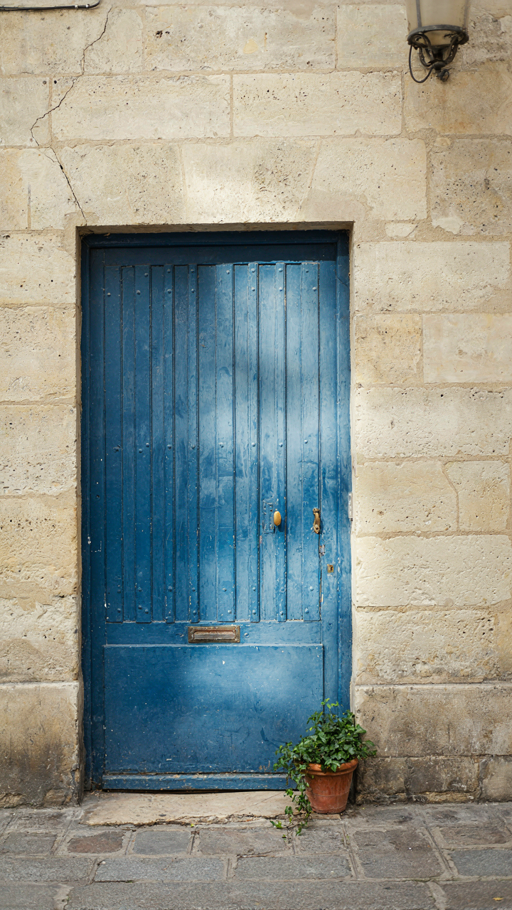 A vibrant french blue door, with one side slightly faded from direct sunlight exposure.