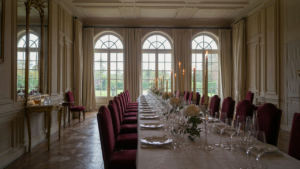 Elegant French chateau dining room, long table, white linens, and crystal stemware.