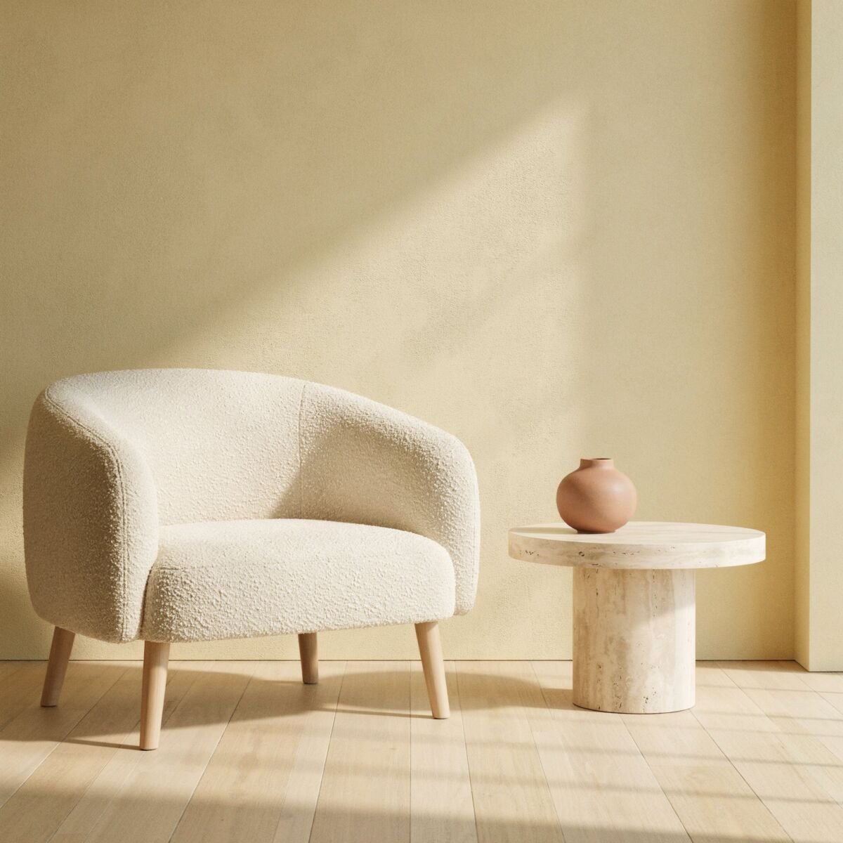 Boucle armchair and travertine side table against a warm plaster wall
