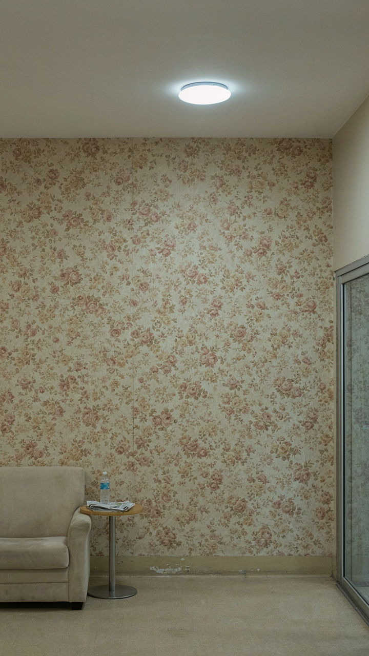Faded, generic floral wallpaper on a wall in a bland hotel lobby.