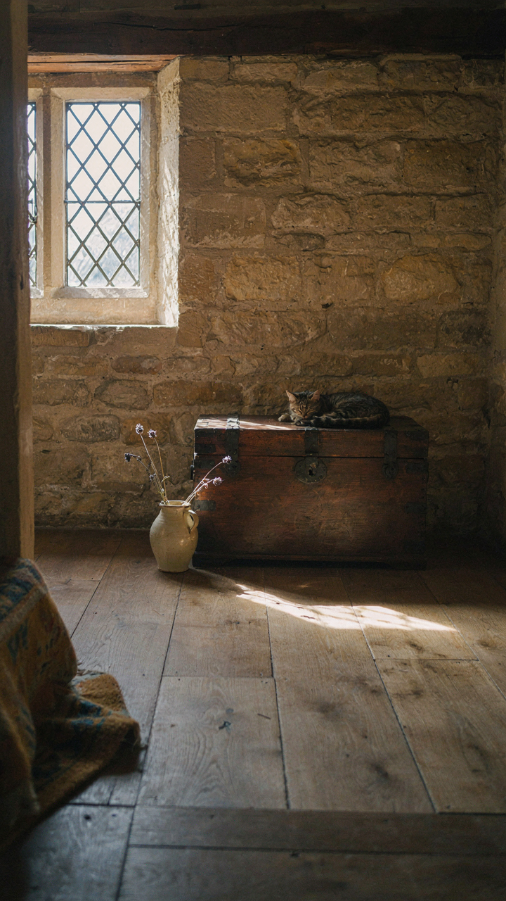 Irregular Cotswold cottage room interior with shadows and sunlight.