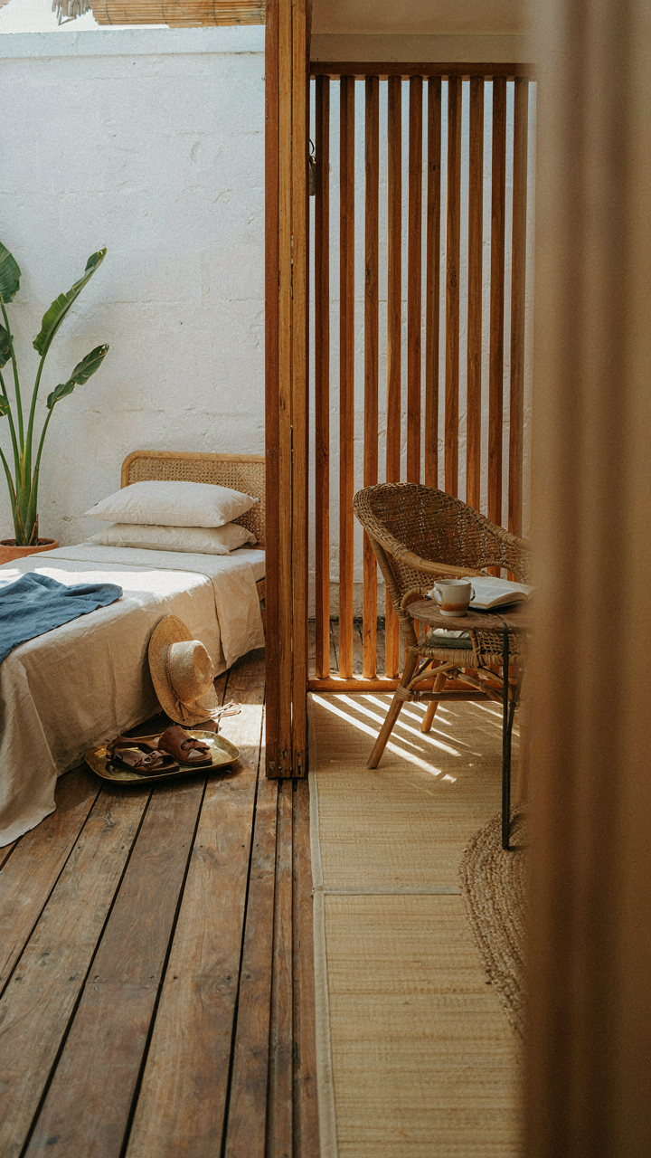 A small beach bungalow interior with a sliding screen dividing two areas.