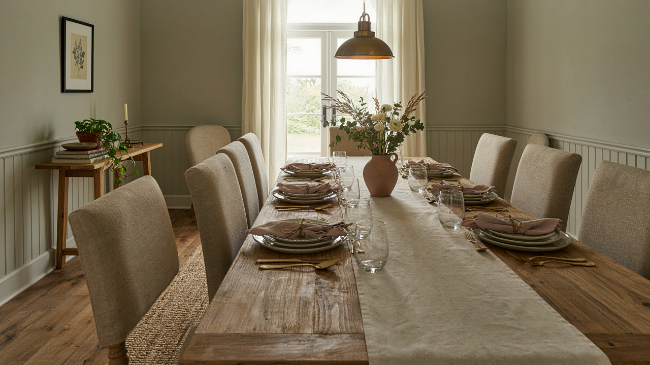 A warm Joanna Gaines dining room with a large wooden table and comfortable chairs.