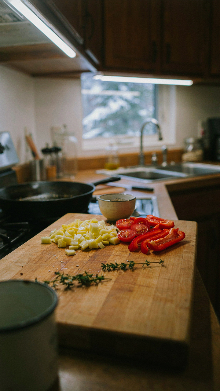 Under-cabinet lights illuminate a cutting board with chopped vegetables.