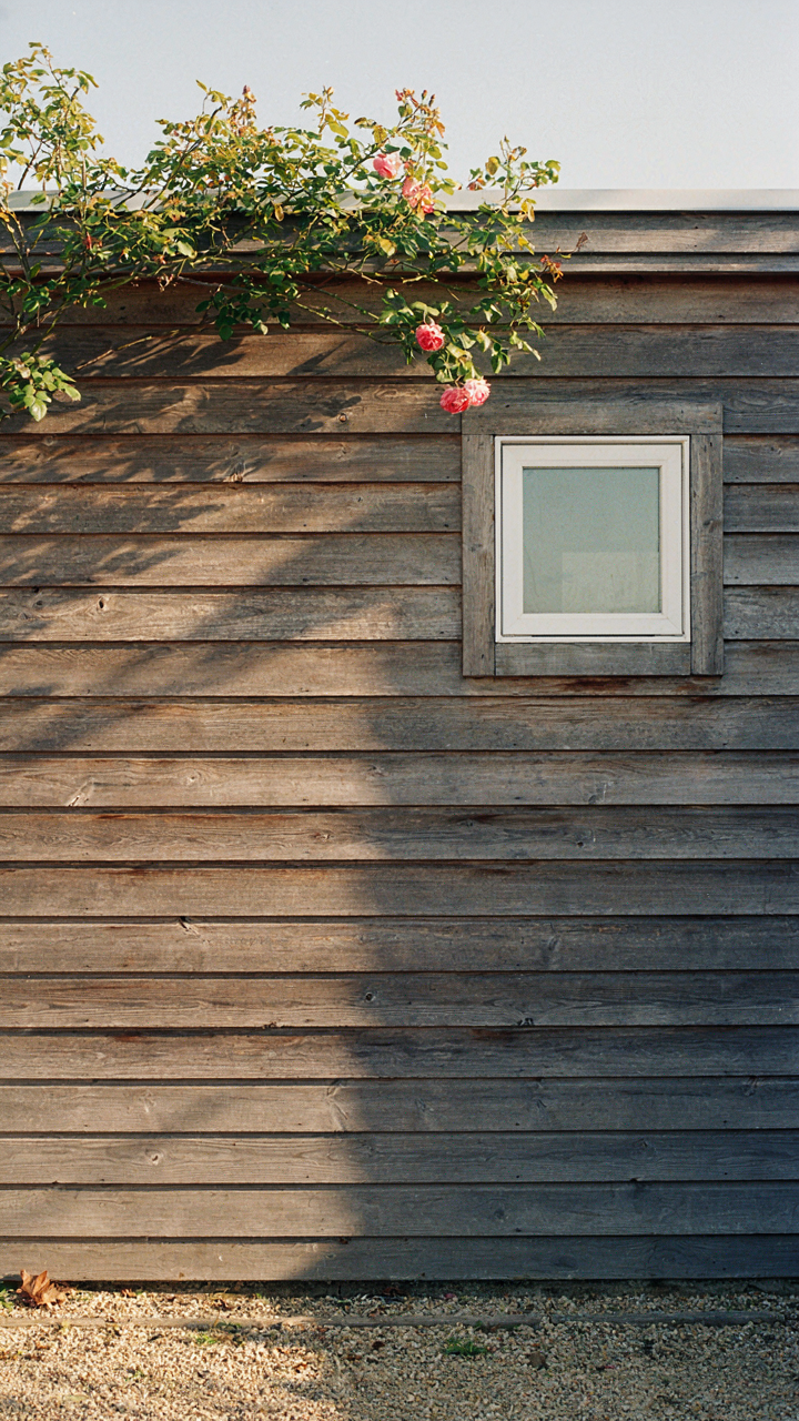 A she shed wall showing a sun and shadow line on the paint.