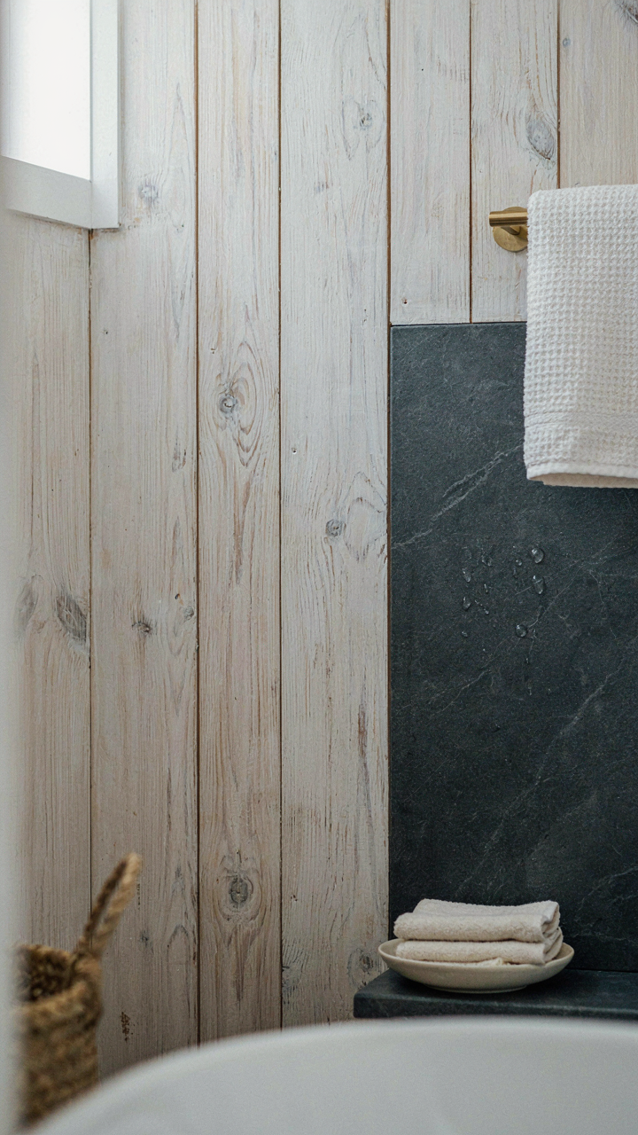 Whitewashed pine wood panels next to a thick honed soapstone surface.
