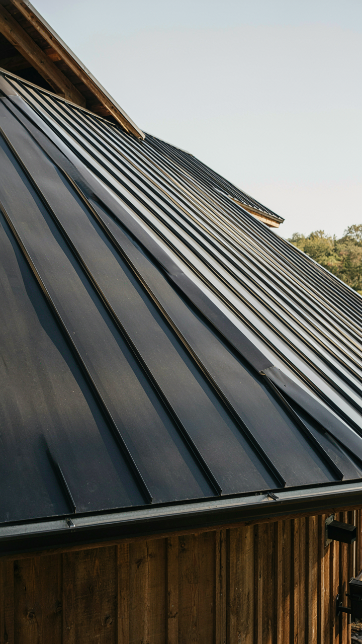 A close-up of a modern metal roof on a barn house, showing clean lines.