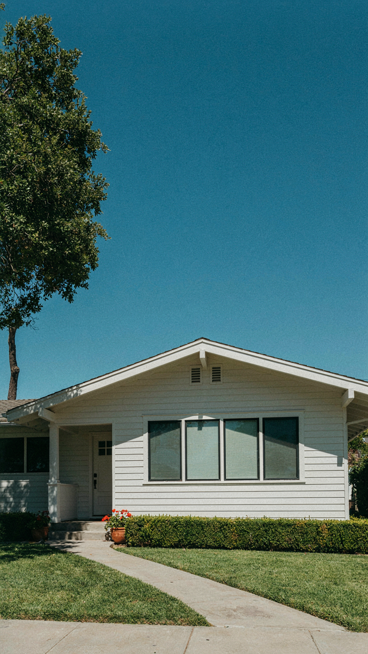 A deep roof overhang casts a shadow on a south-facing window of a California bungalow.