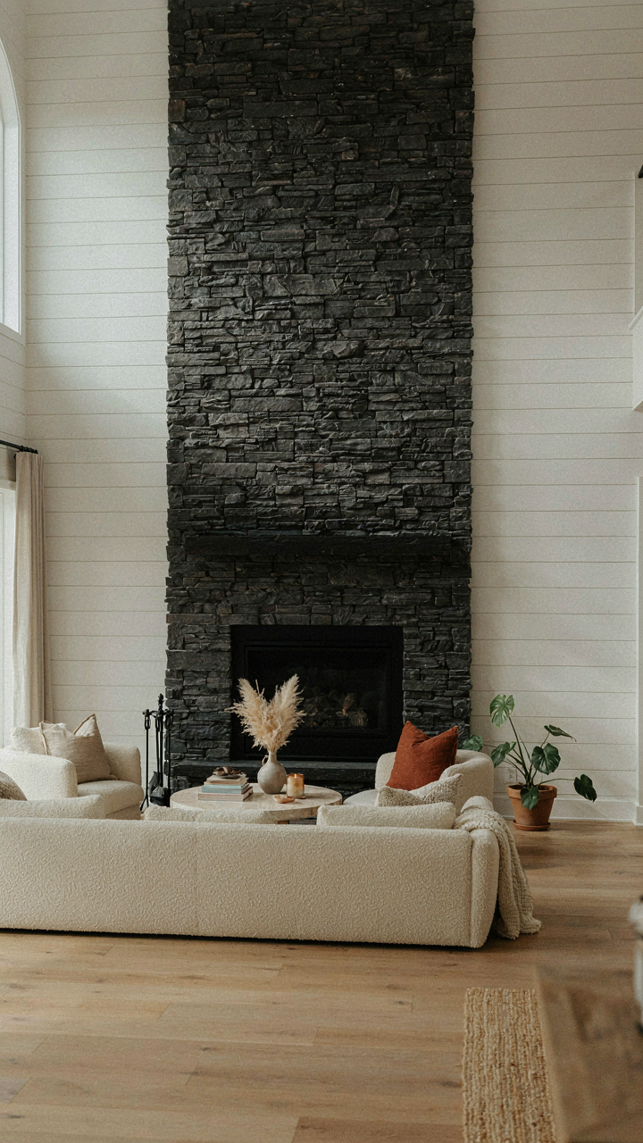 A white shiplap fireplace wall with a dark stacked stone surround.