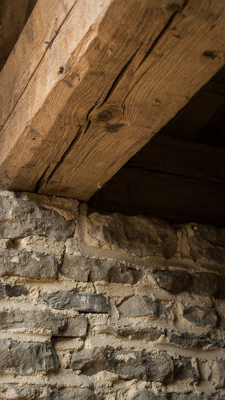A weathered timber beam shows natural cracks from expansion and contraction.