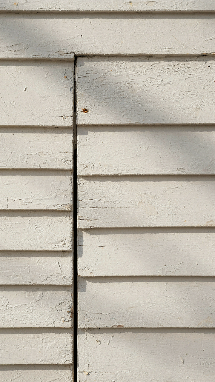 Close-up of weathered clapboard siding on a colonial farmhouse.