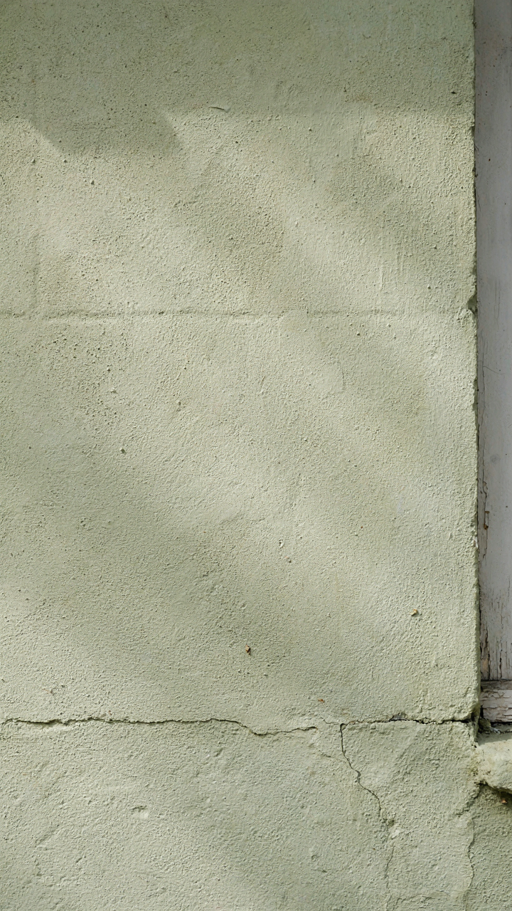 A lime-rendered wall on a scandinavian bungalow reflects soft northern light.