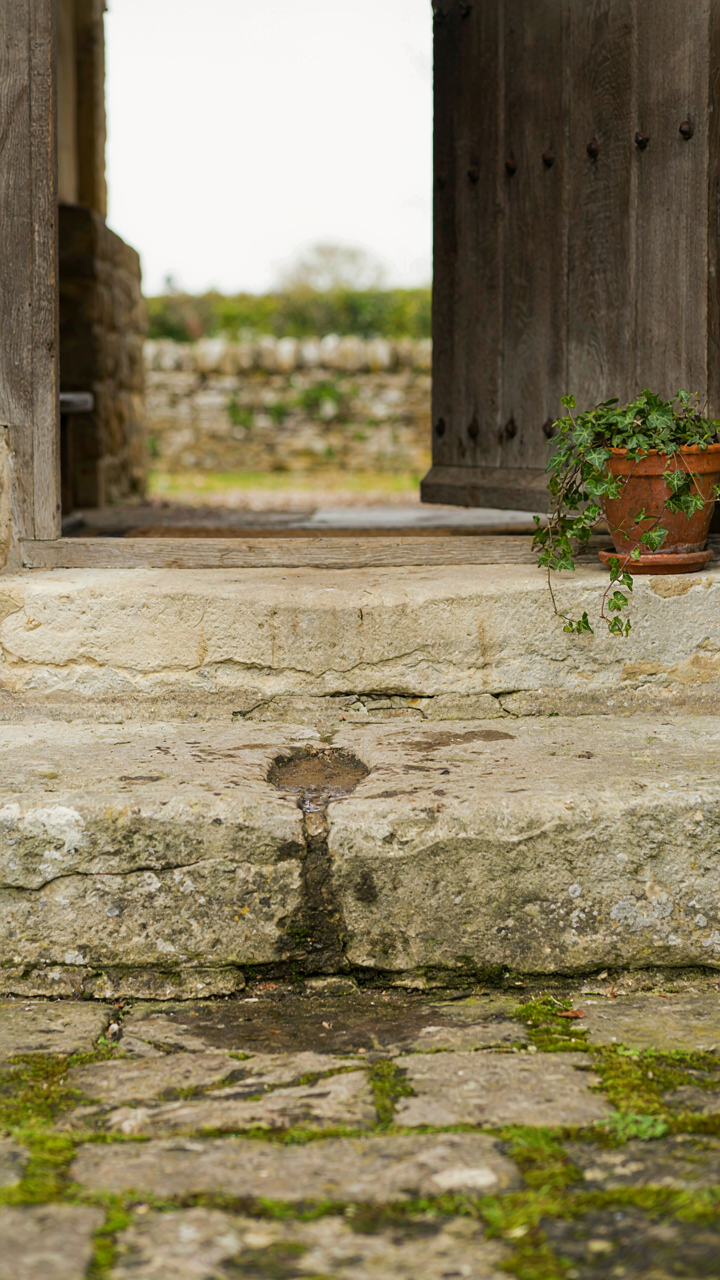 A very worn stone doorway of an old English farmhouse.