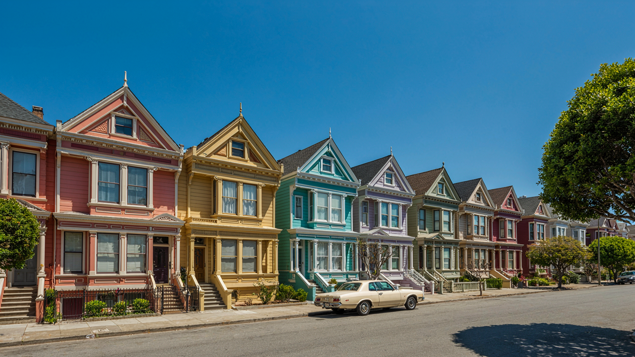 A vibrant row of painted lady houses, showing their bold colors and unique Victorian architecture.