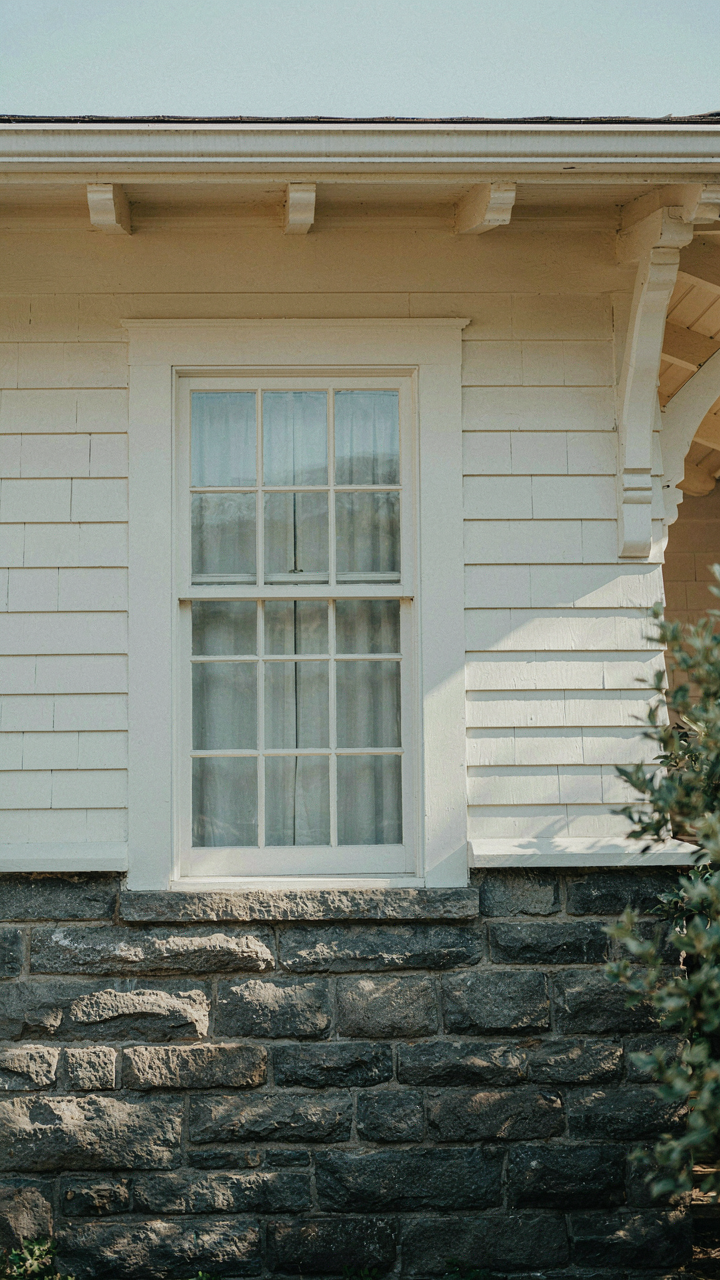 Dark stone foundation with lighter trim on a craftsman bungalow exterior.