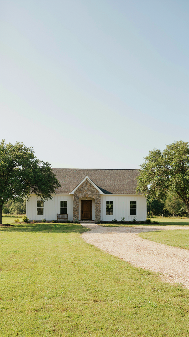 A ranch farmhouse exterior with board and batten siding and a stone entryway.