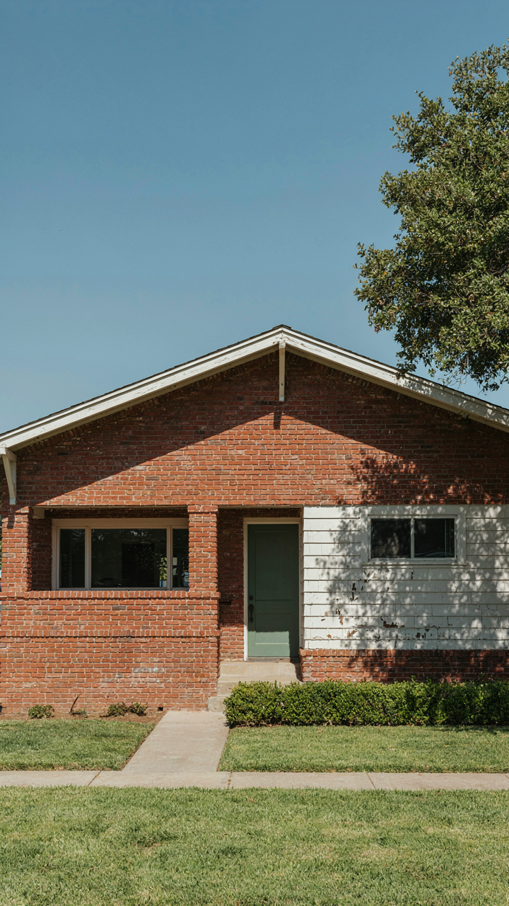 A California bungalow showing red brick and white weatherboard on its exterior walls.