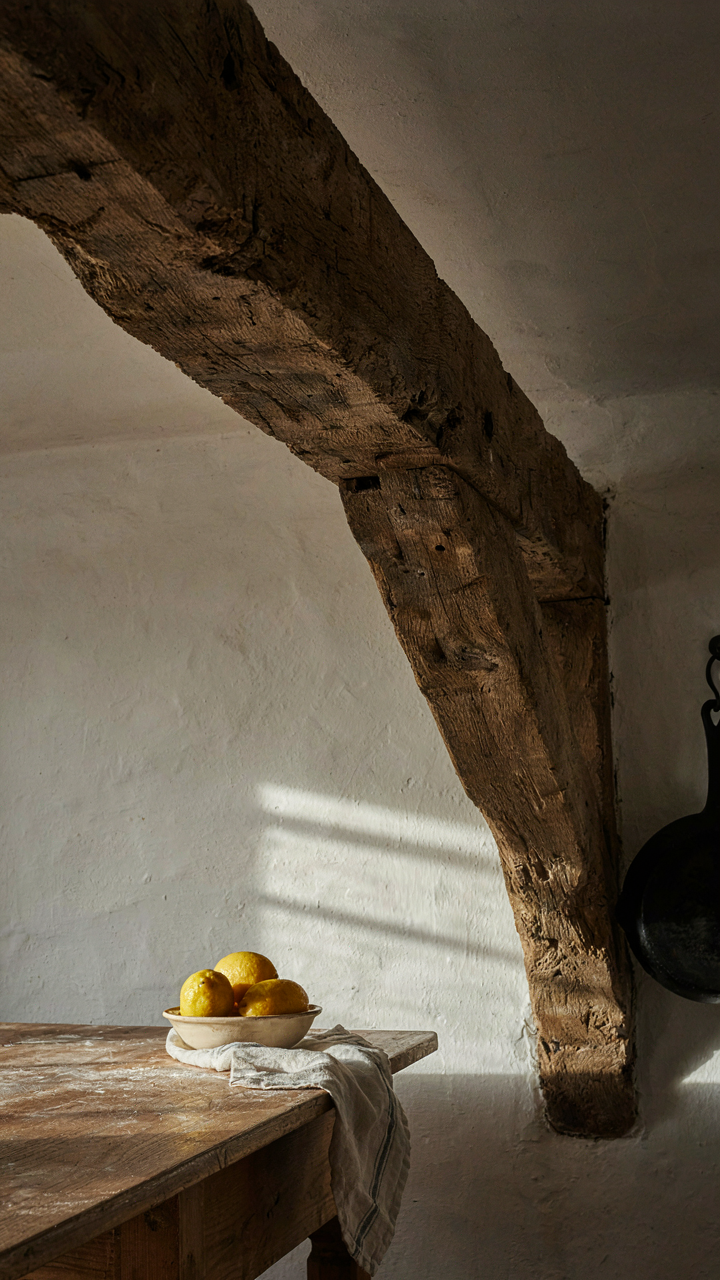 Sunlight rakes across a large wooden beam, creating strong shadows.