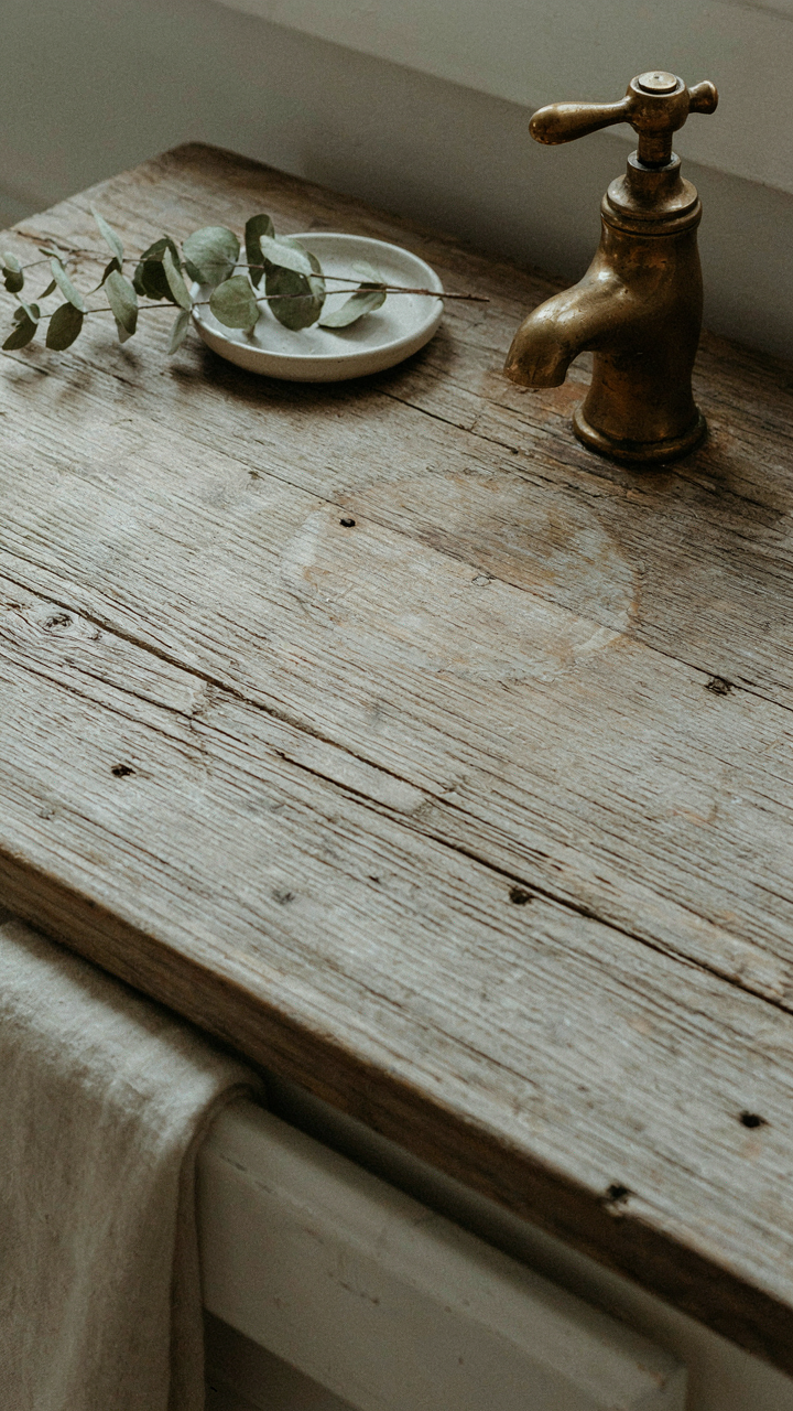A close up of an old barn wood vanity top with cracks and color changes.