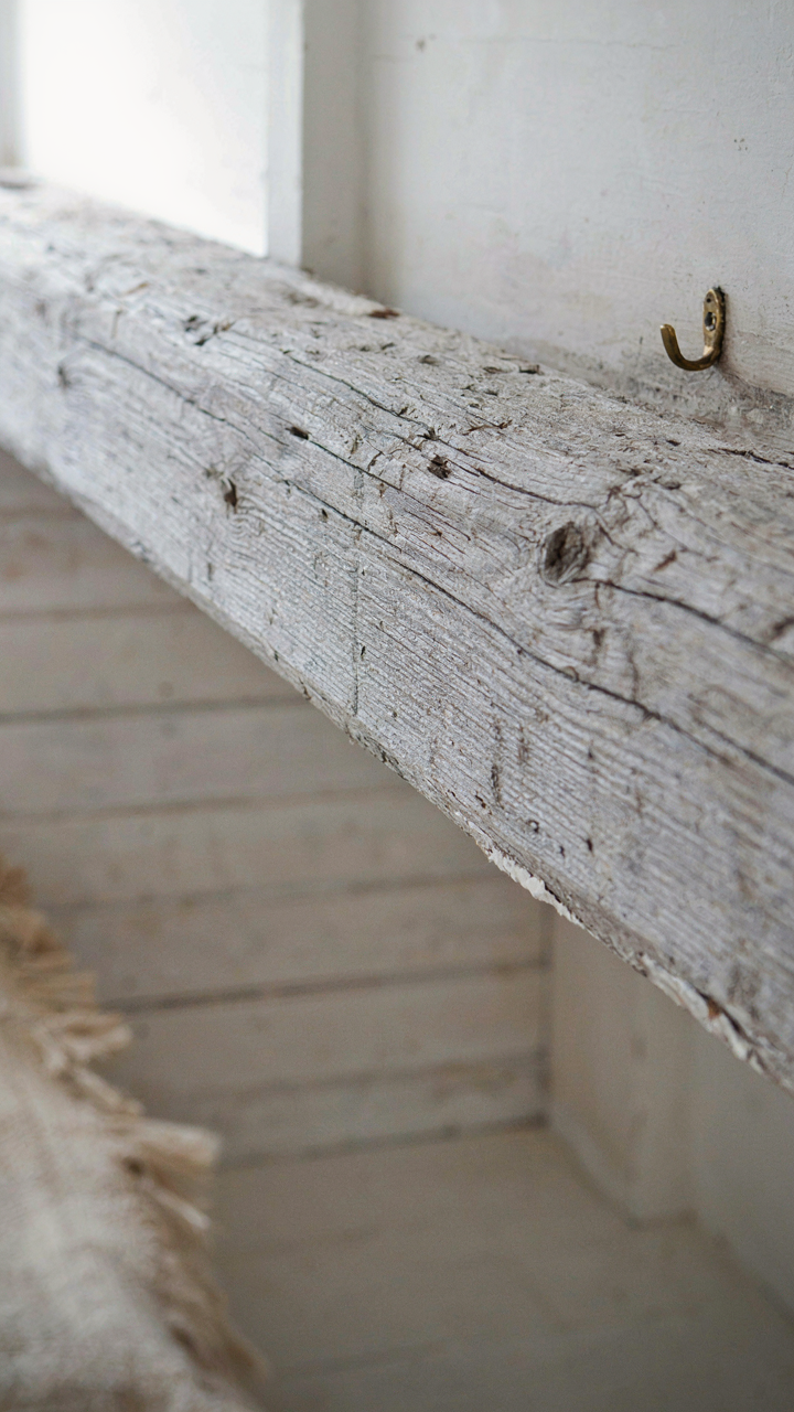 A weathered wooden beam shows cracks and patina from salt exposure.