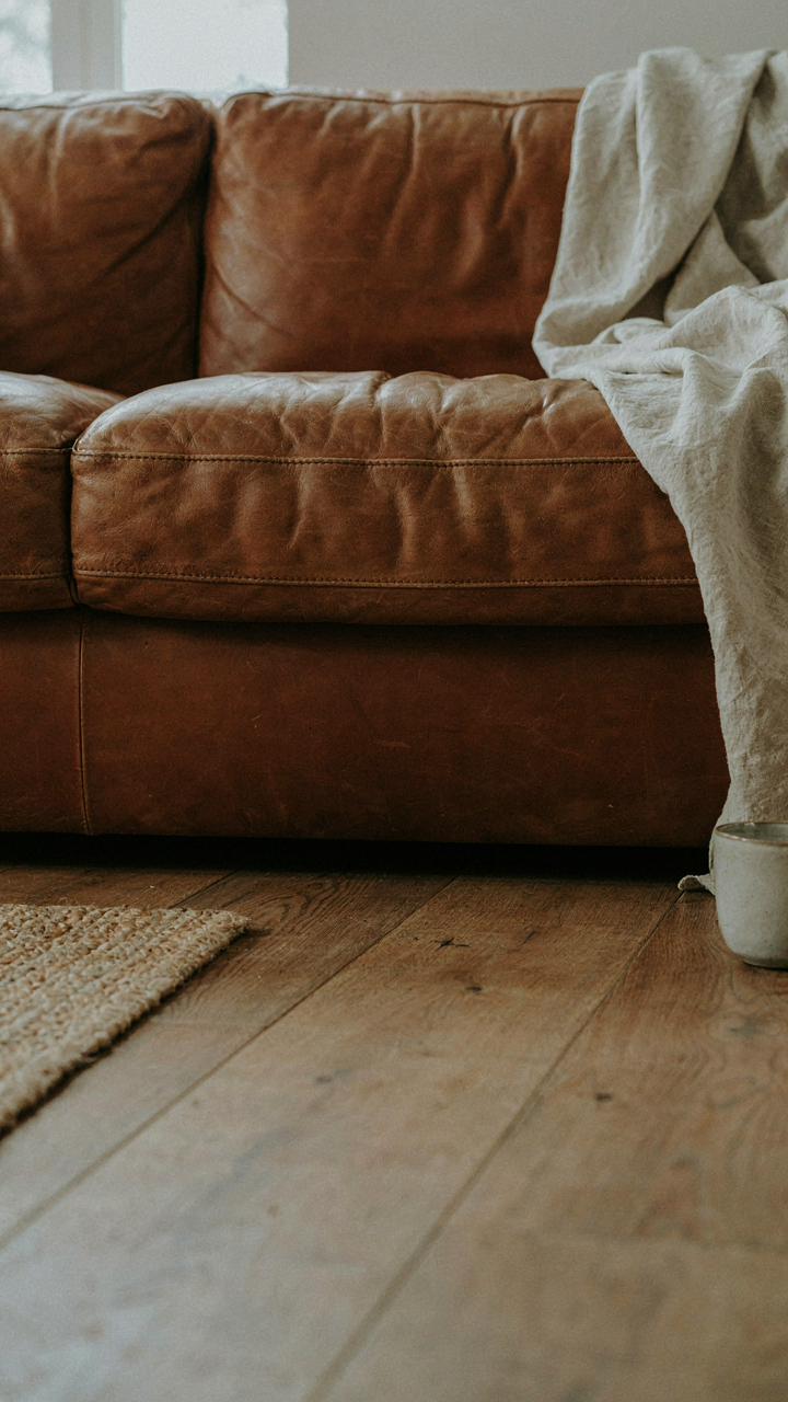 A close-up of a worn leather sofa cushion with natural creases.