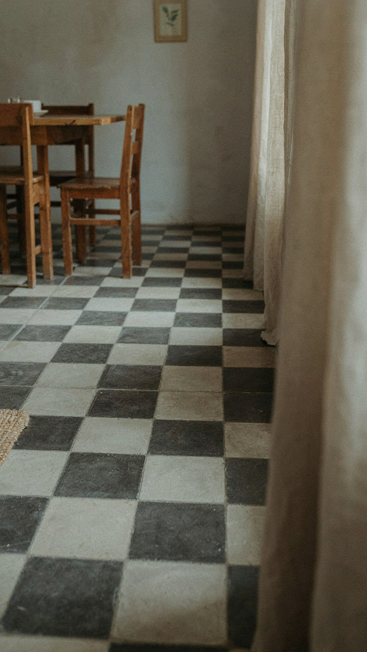 A rustic cottage dining room with a classic black and white checkered floor.