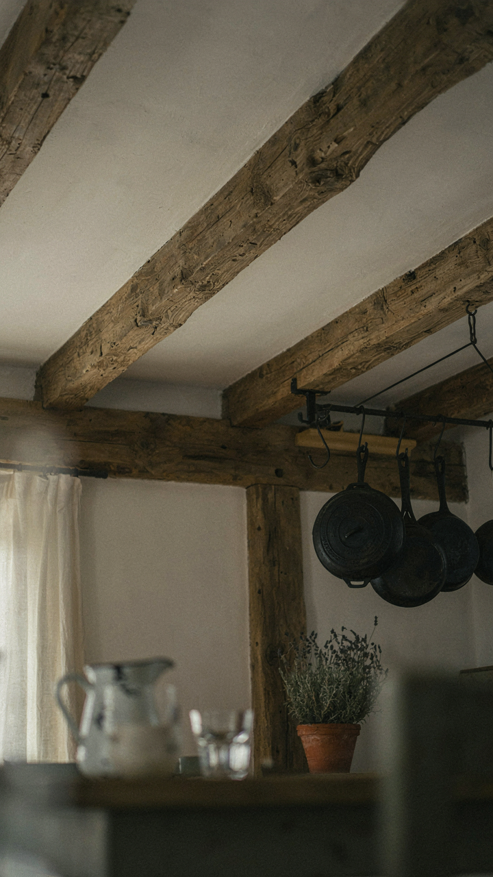 Close-up of a reclaimed wood beam and cast iron cookware, indicating age and history.