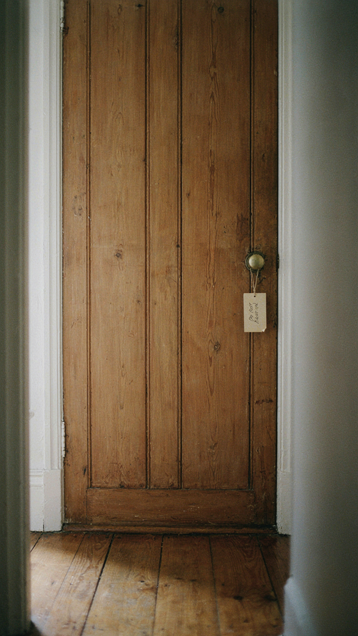 A closed rustic wooden door with a 'Do Not Disturb' sign.